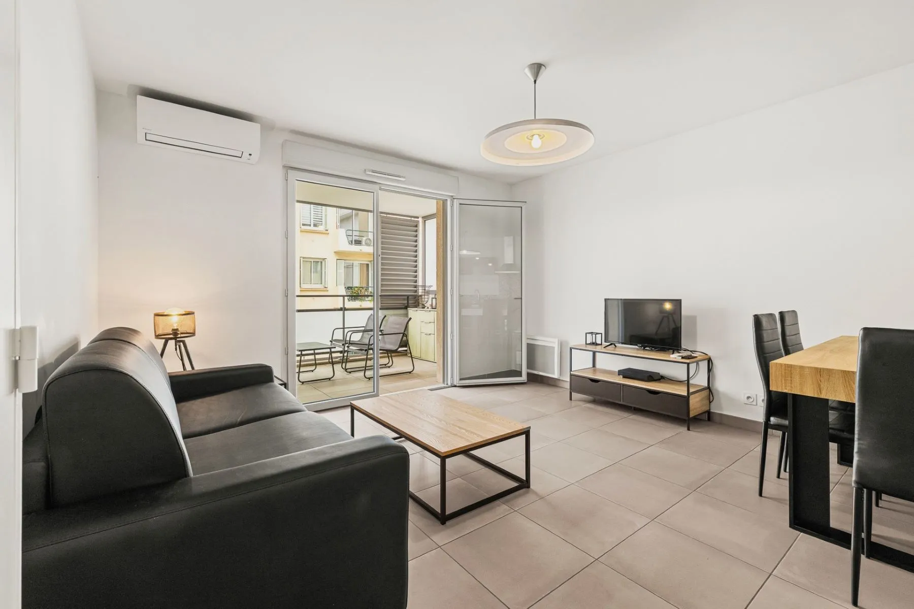 Air-conditioned living room with television and glazed doors opening onto the terrace