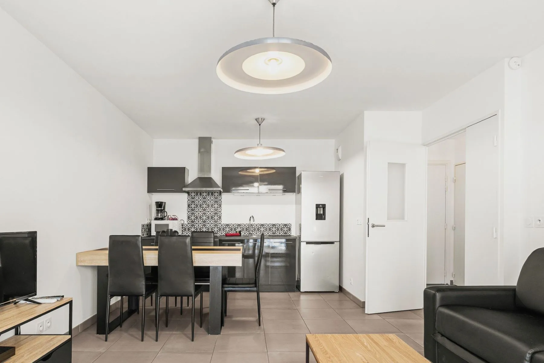Open-plan dining and kitchen area viewed from the lounge in the Le Port apartment