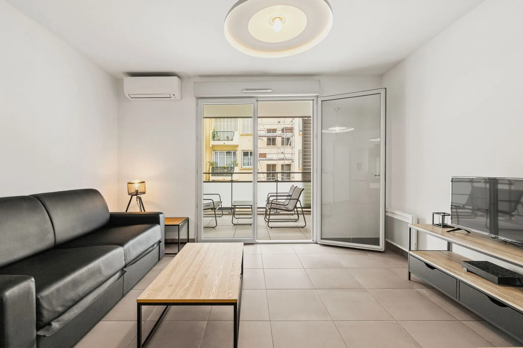 Lounge with timber coffee table and full-height doors leading to the furnished terrace