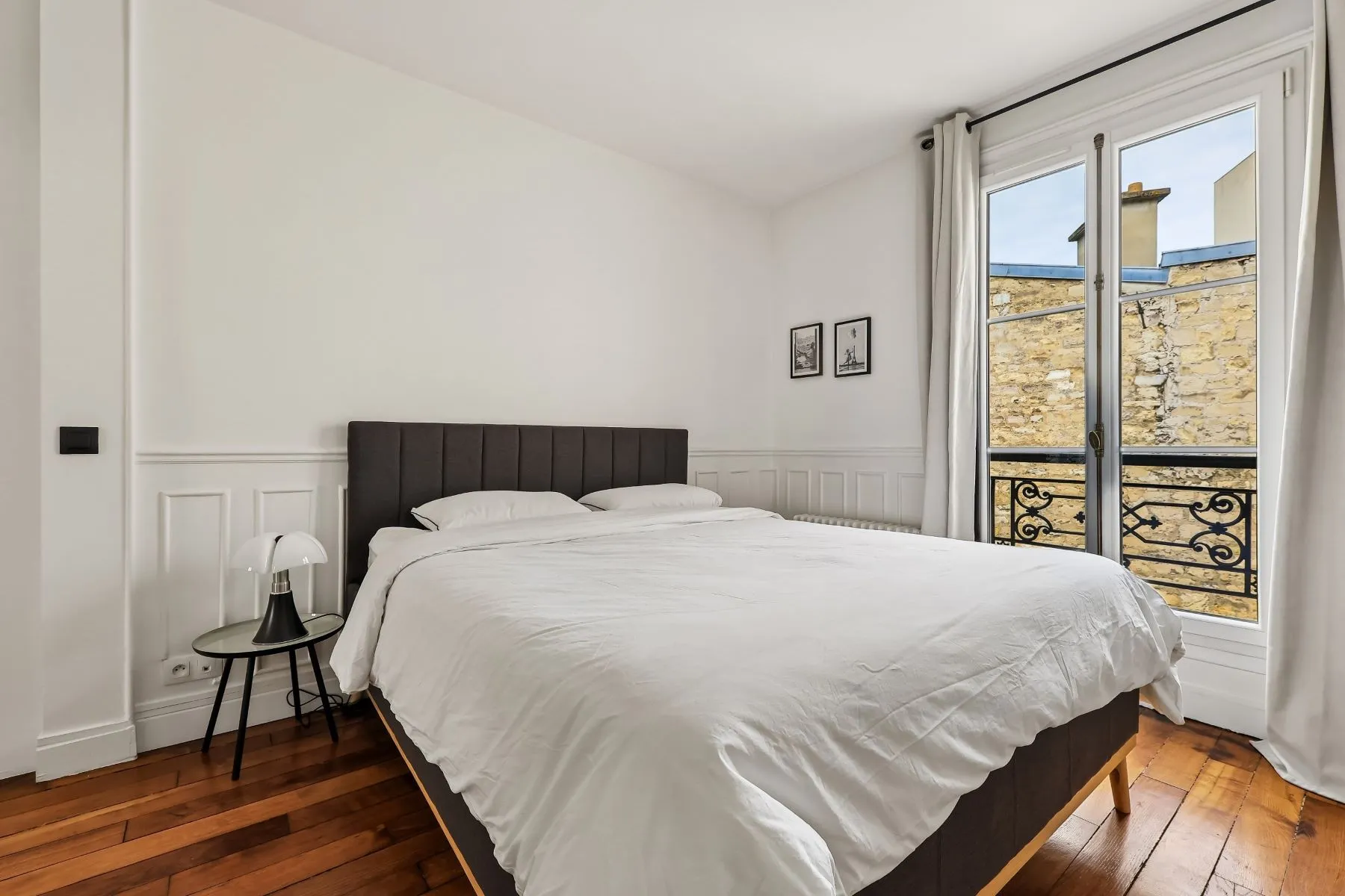 First double bedroom with upholstered headboard, white bedding and tall window