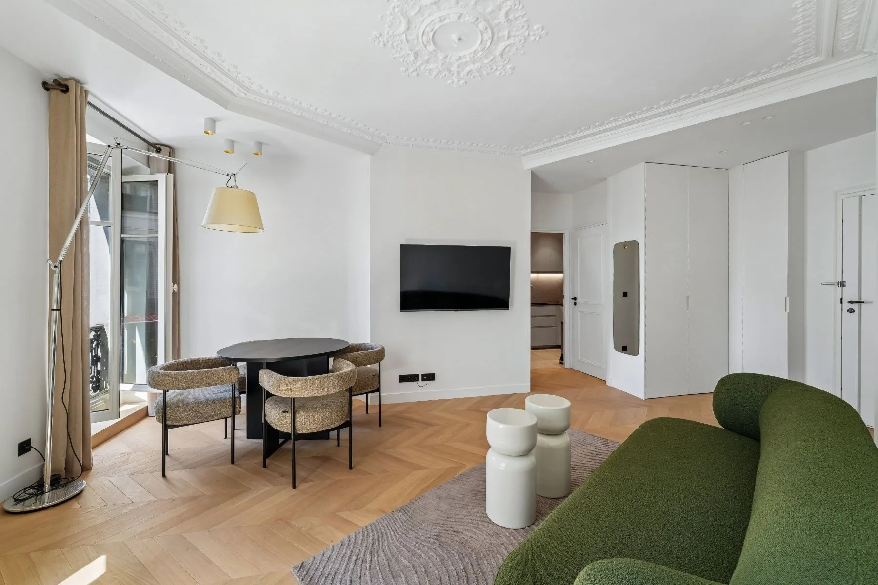 Montmartre living and dining room with green sofa, parquet flooring and ornate ceiling mouldings