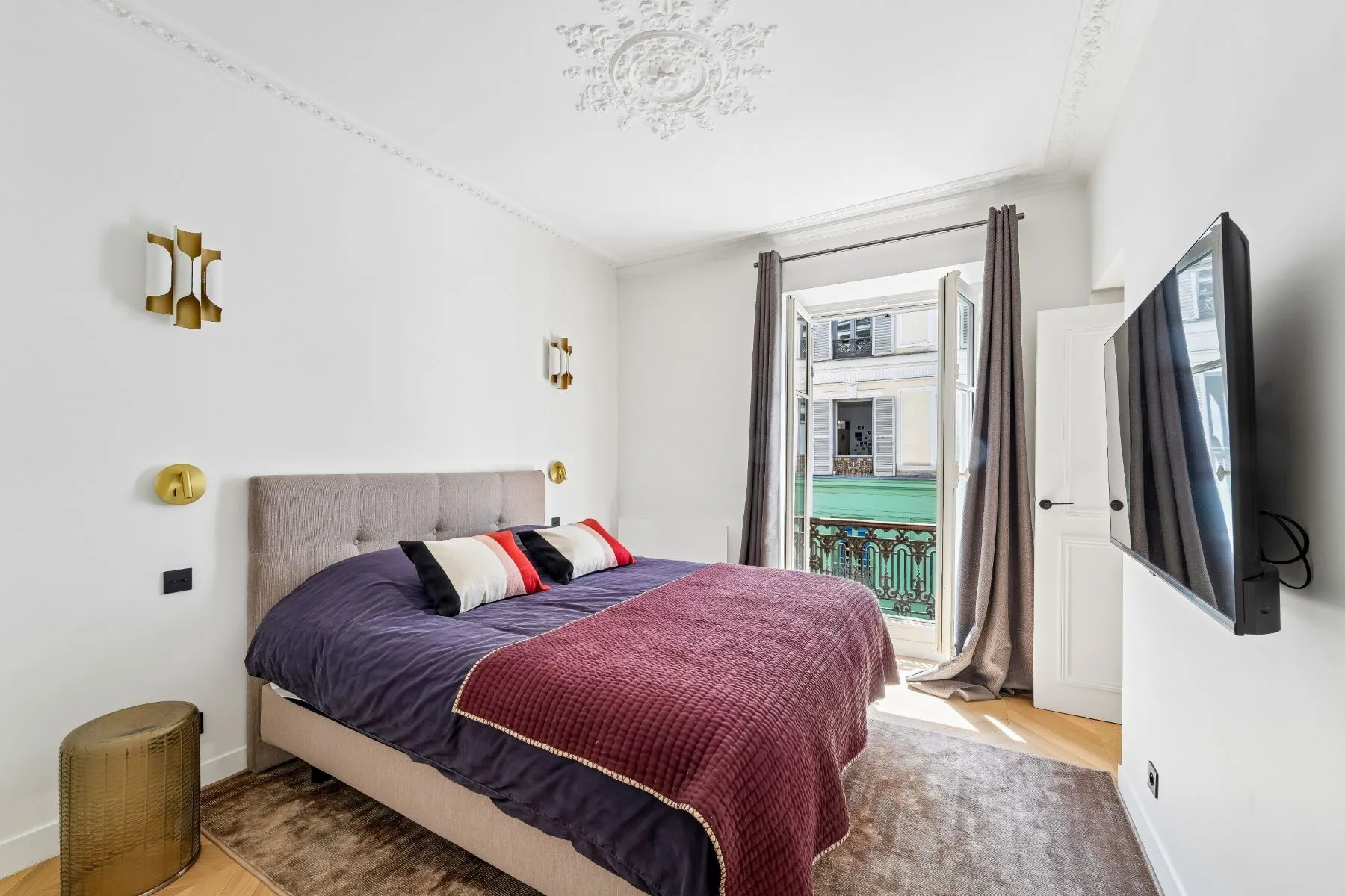 Second double bedroom with upholstered headboard, burgundy throw and full-height window