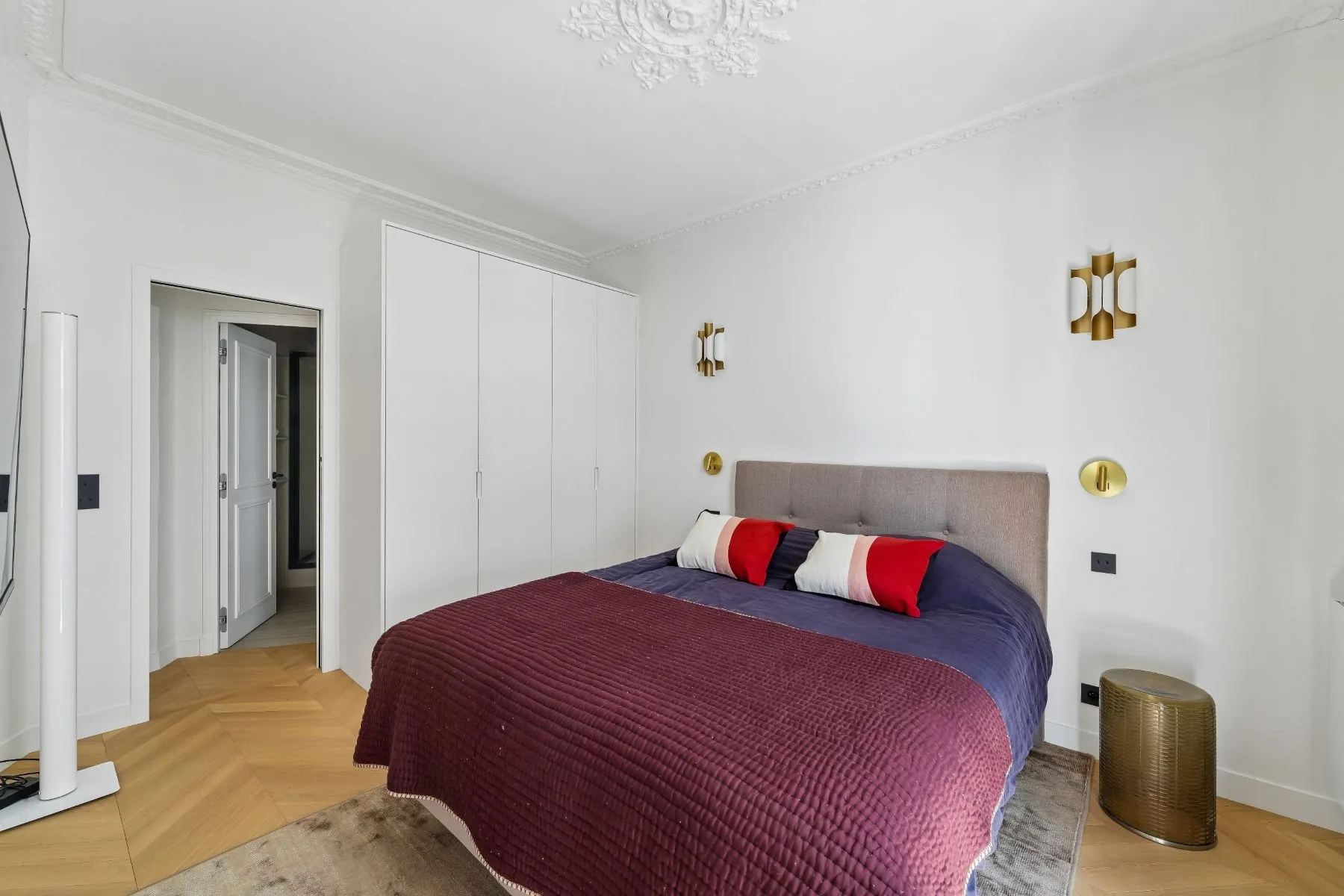 Second bedroom with fitted white wardrobes, gold wall lights and ornate ceiling rose