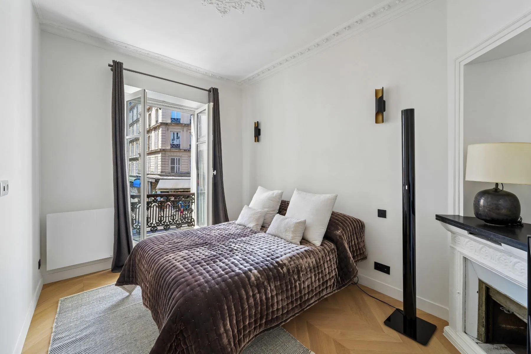 First bedroom with double bed, decorative fireplace and original ceiling mouldings