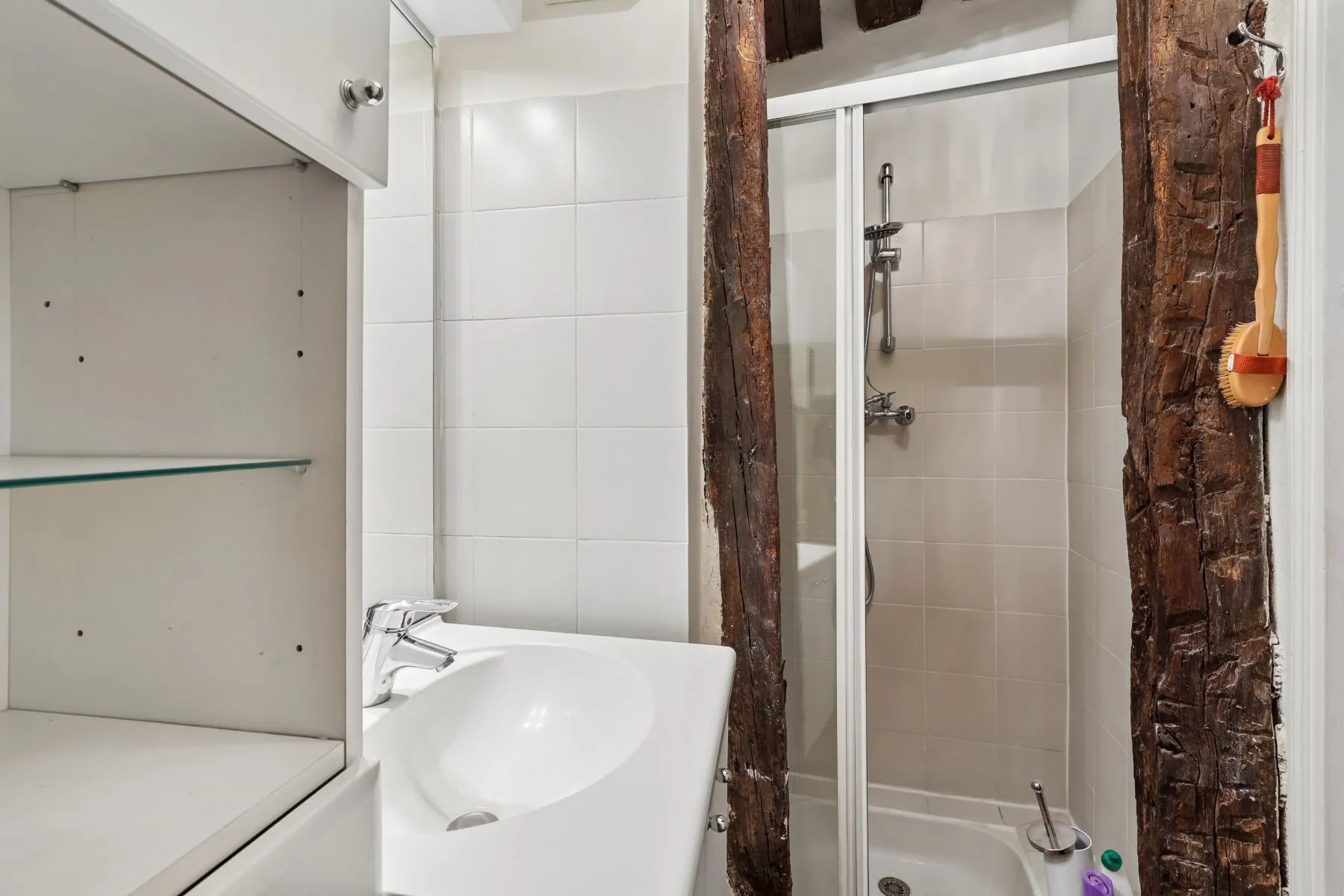 Apartment bathroom with bathtub overhead shower and original timber detail
