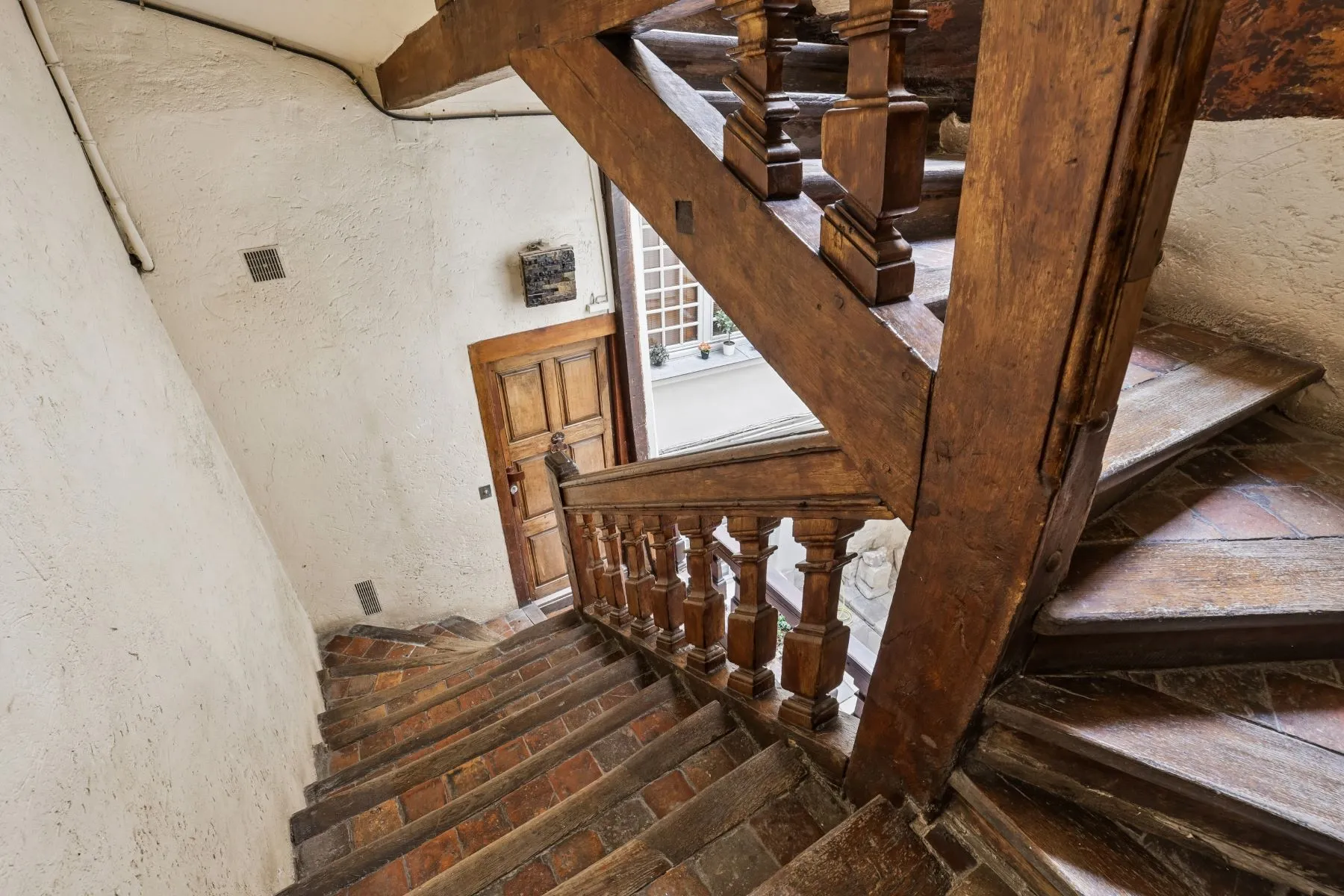 Historic timber staircase leading to the second-floor Paris apartment