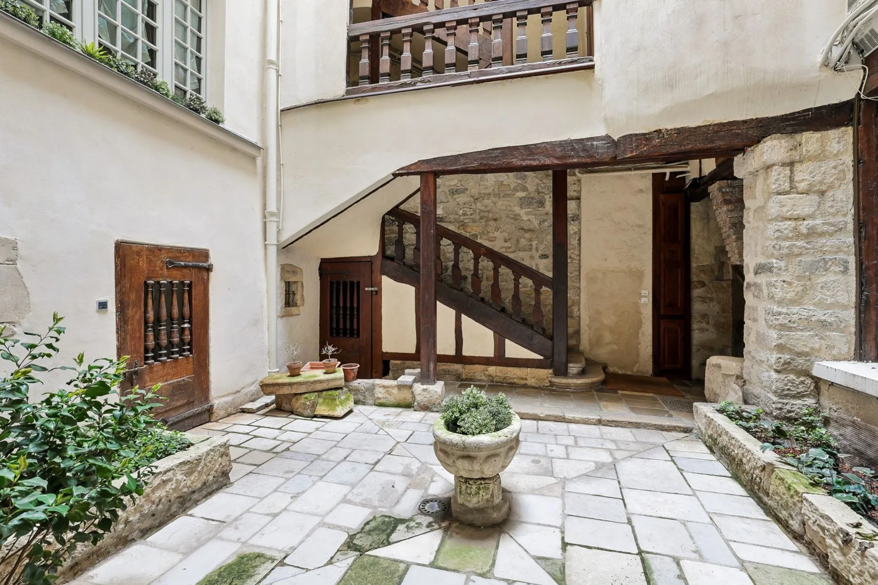 Quiet planted inner courtyard and traditional timber stair entrance