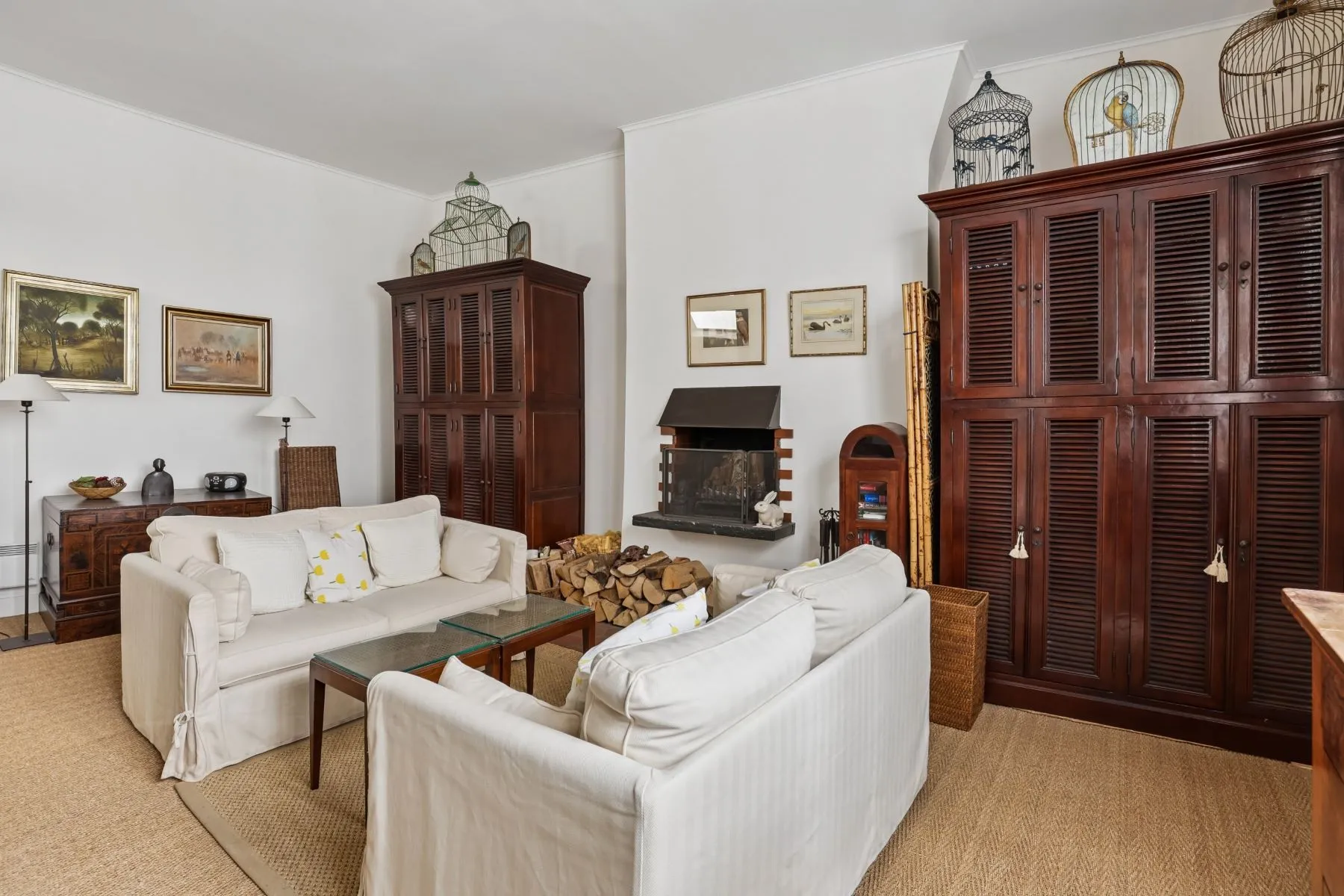 Peaceful courtyard-facing lounge with sofas and antique timber storage