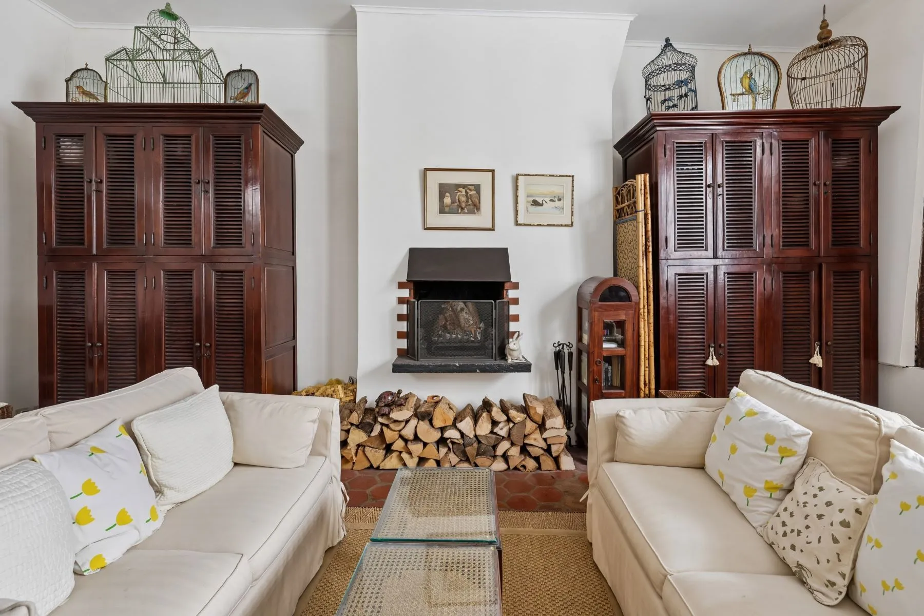 Working log fireplace arranged between antique Parisian cabinets