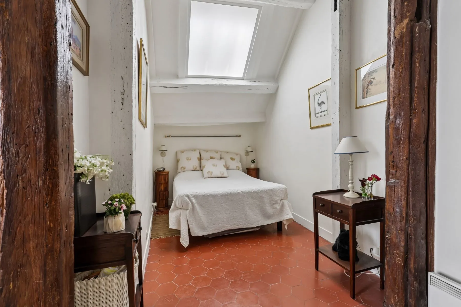Intimate double bedroom beneath a bright courtyard-facing window