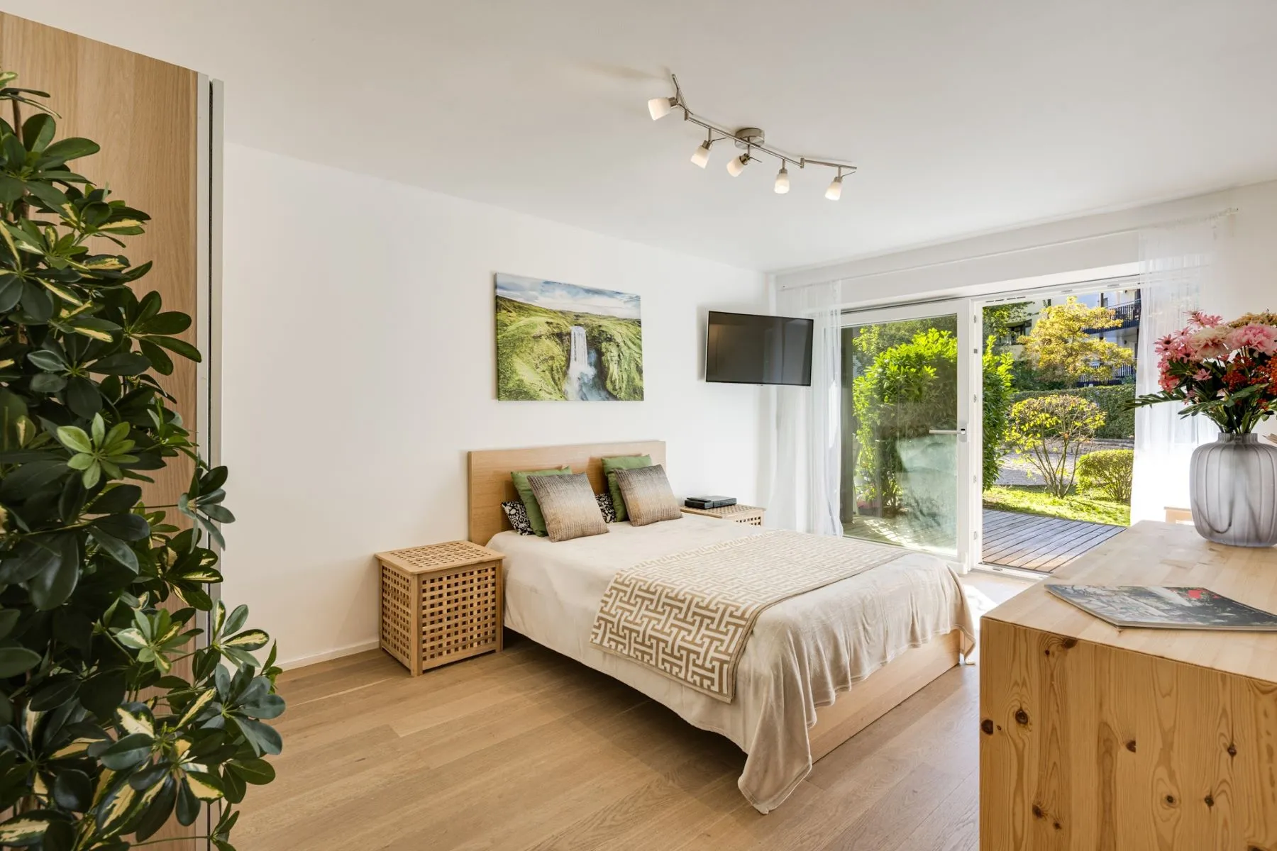 Sunlit double bed and oak parquet flooring overlooking the private garden