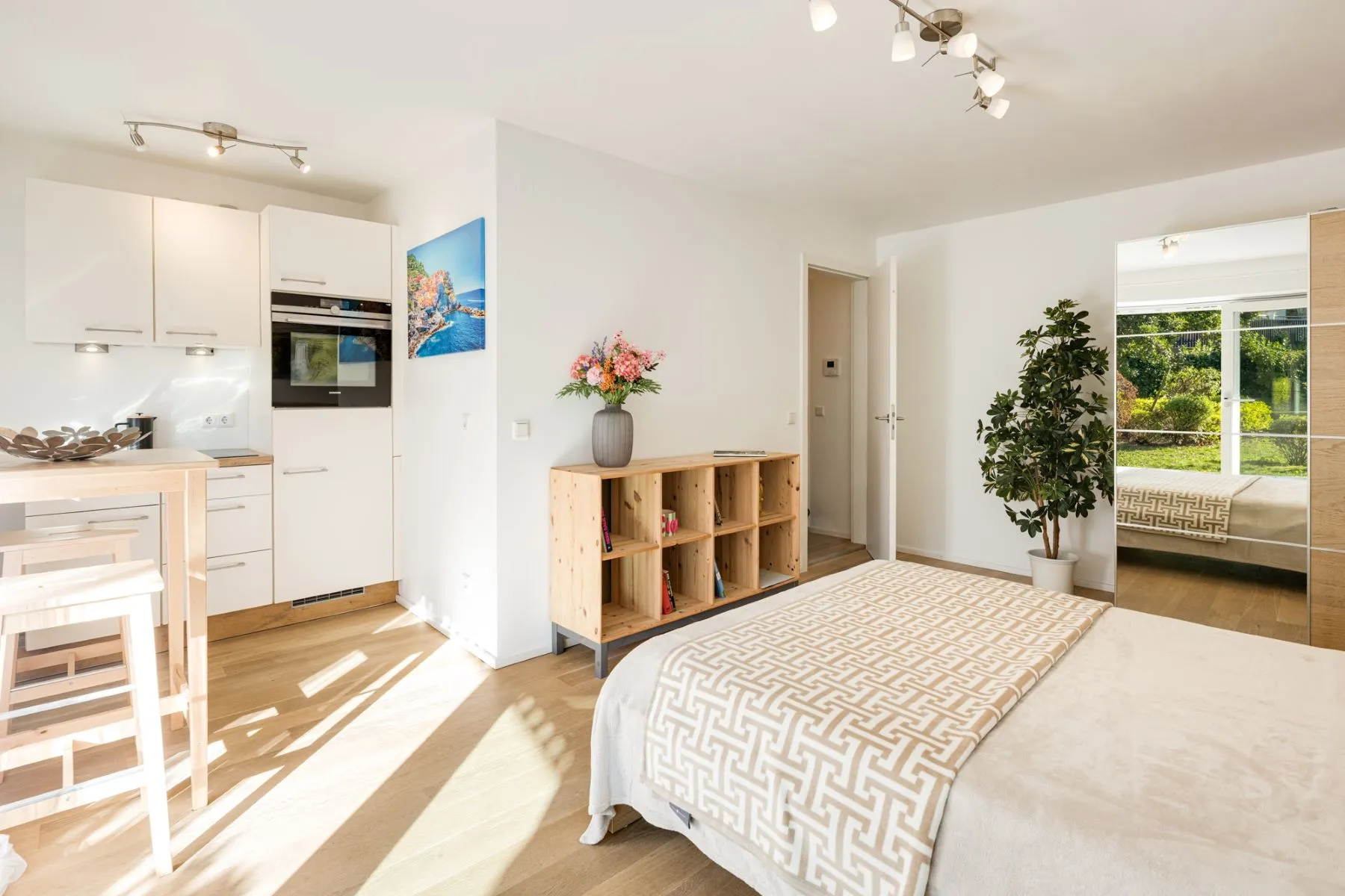 Integrated studio kitchen with built-in oven beside the sleeping area
