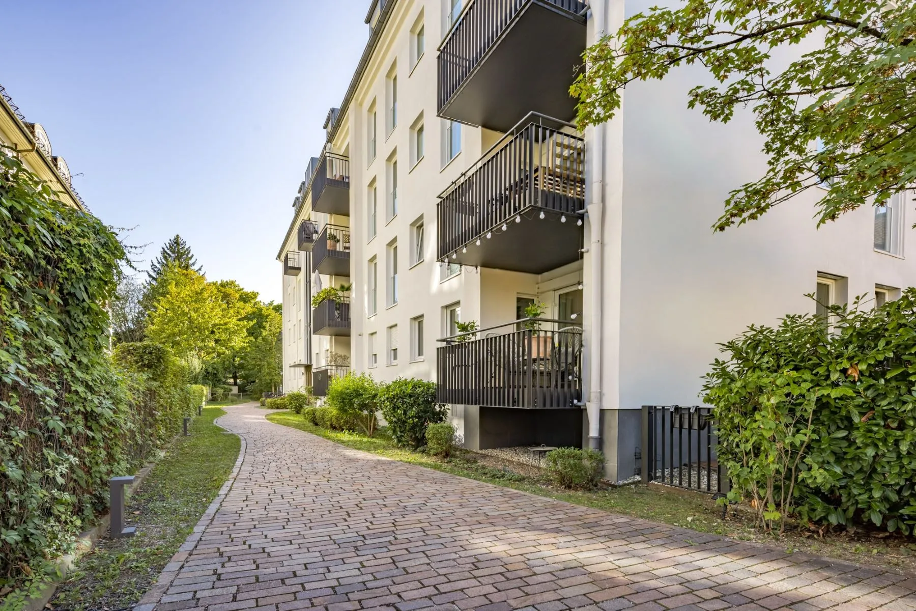 Paved pedestrian path beside the landscaped Nymphenburg residential building