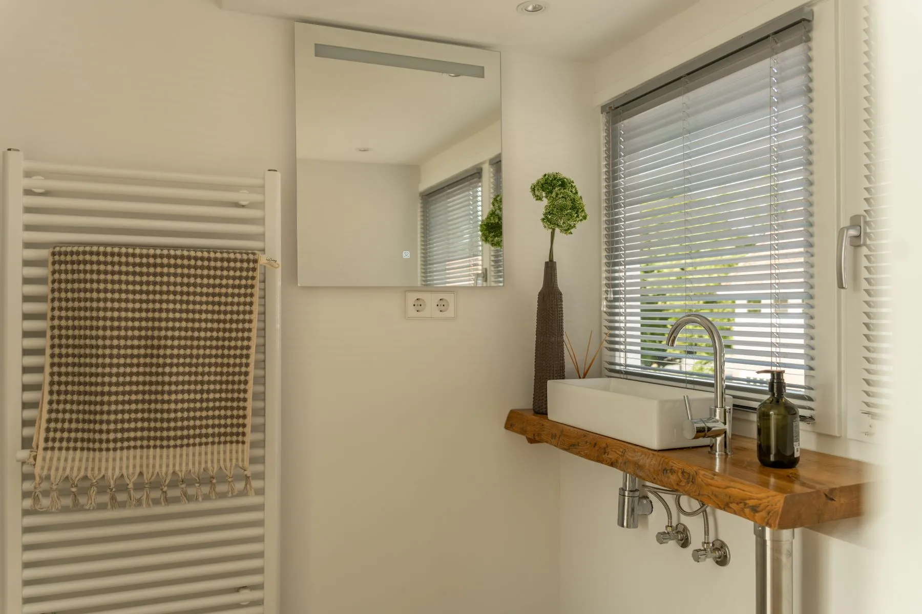 Practical guest washroom with basin and heated towel rail