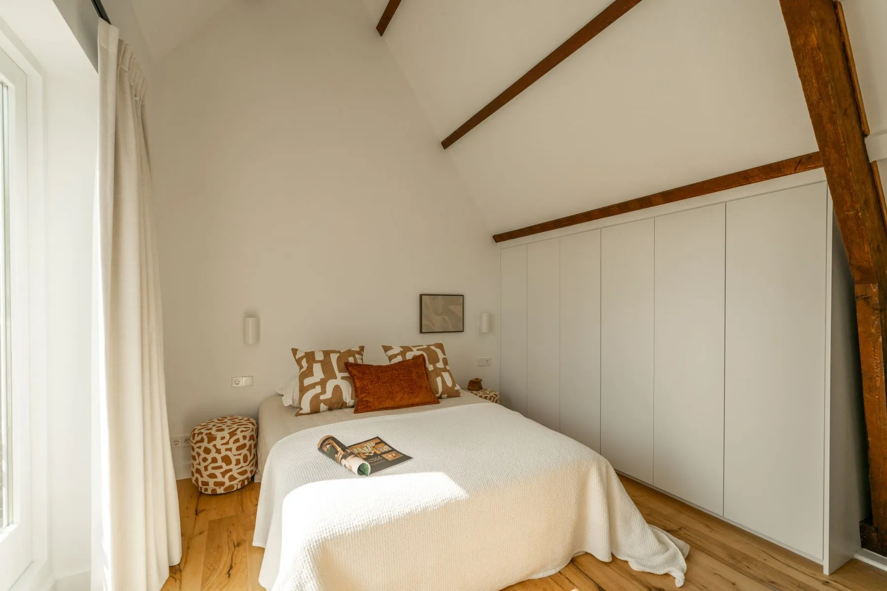 Upper principal bedroom with custom wardrobes and exposed timber beams