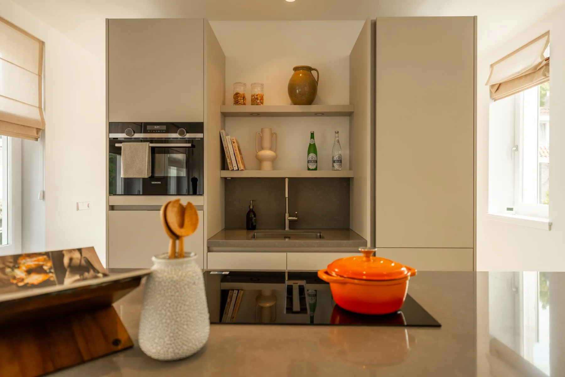 Modern fitted kitchen with integrated appliances and display shelving