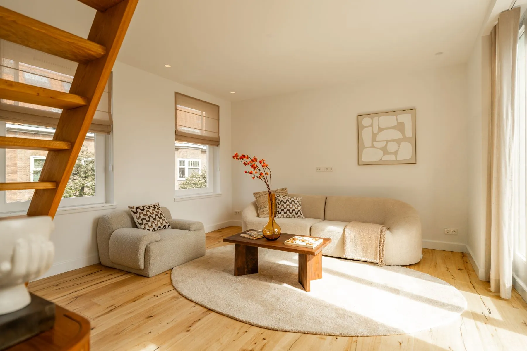 Comfortable living room with neutral sofa and open timber staircase