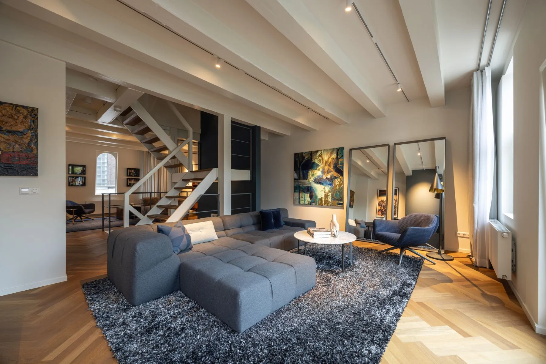 Spacious reception room with herringbone floor and exposed ceiling beams