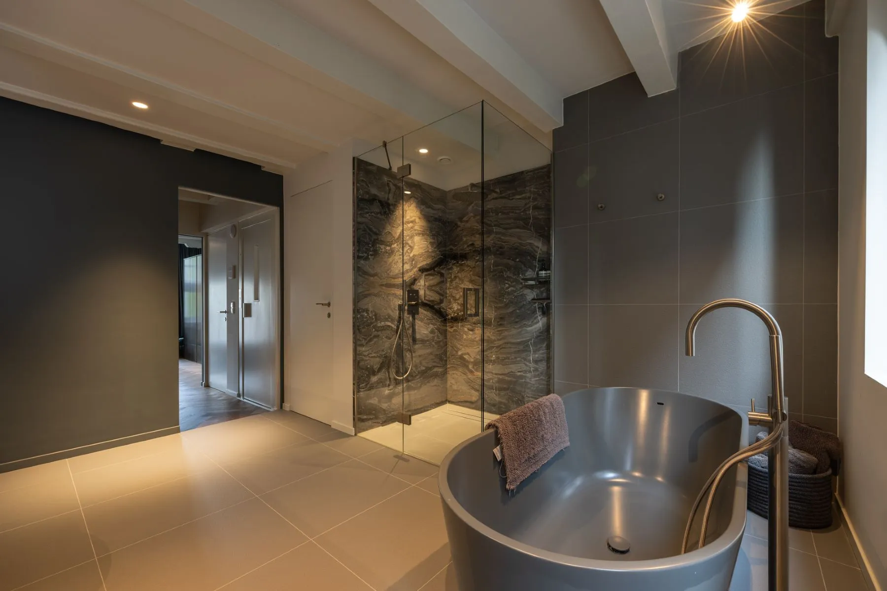 Freestanding bathtub beneath exposed beams in the luxury en-suite