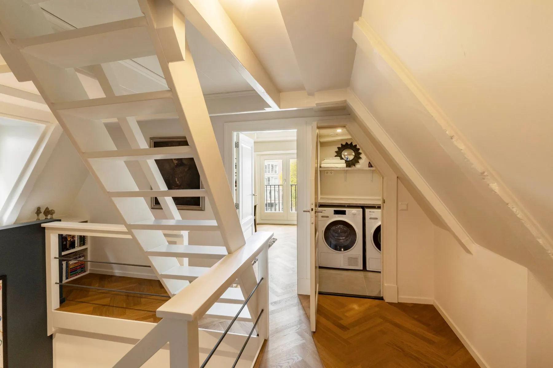 Dedicated laundry area with stacked appliances beside the staircase