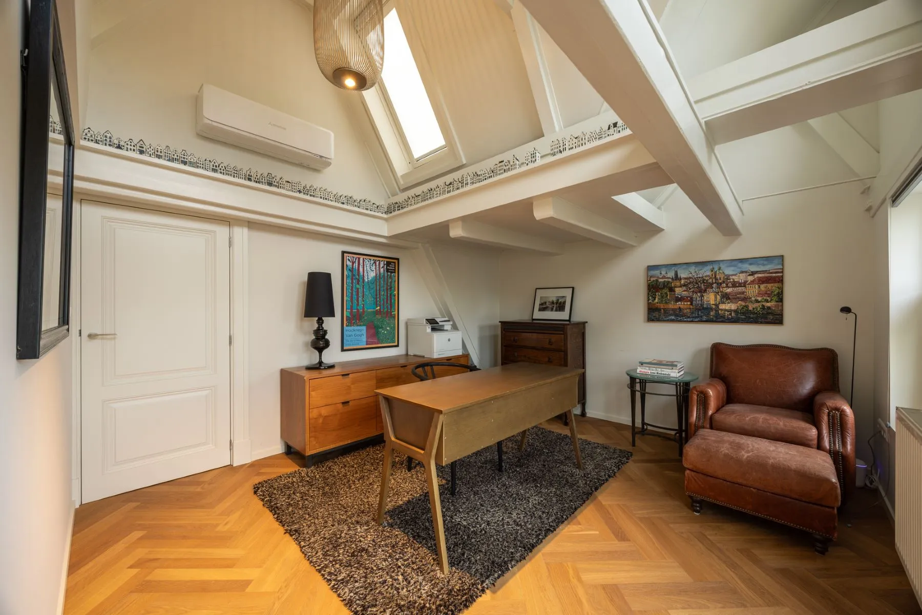 Flexible study lounge with armchair desk and tall Amsterdam windows