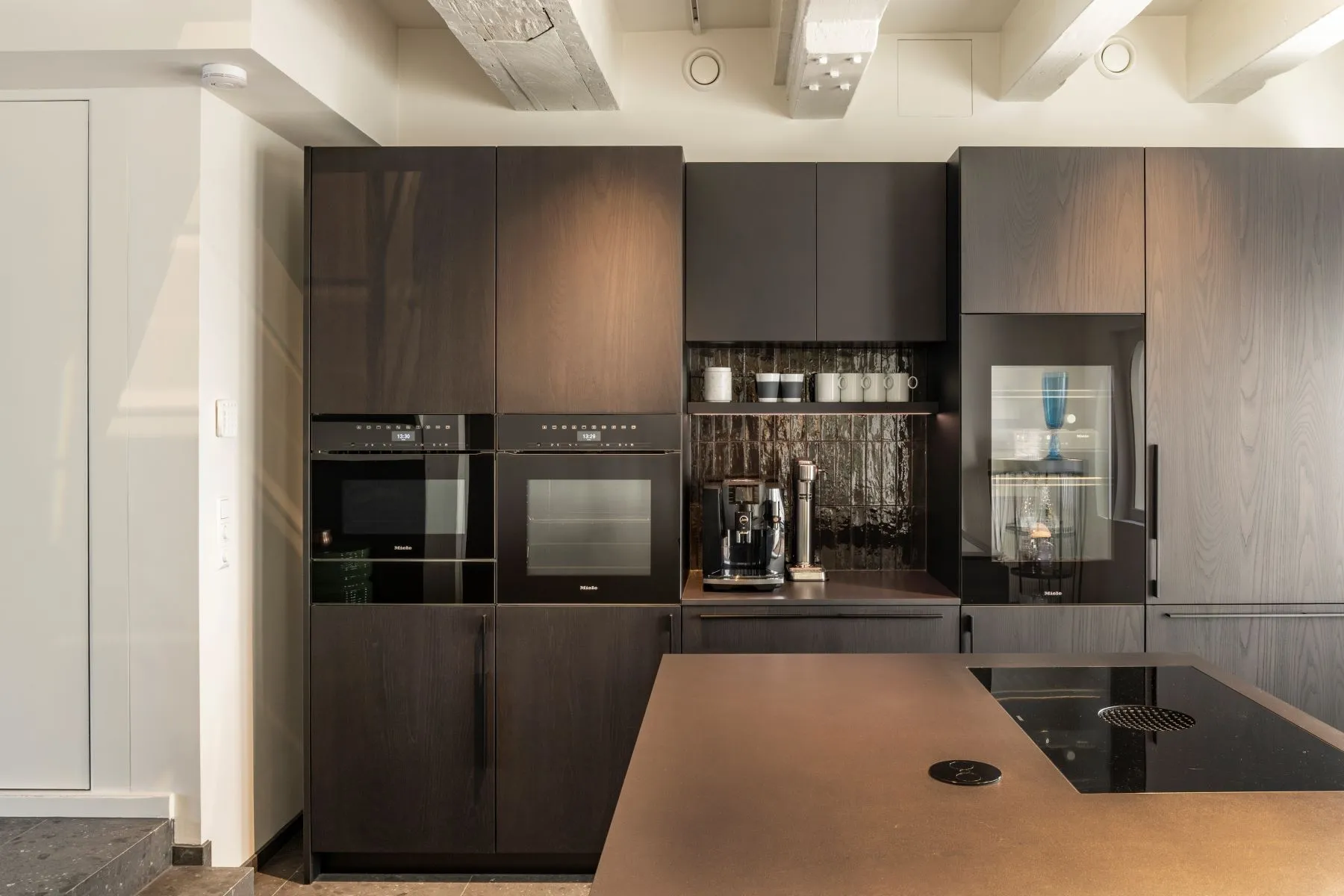Contemporary fitted kitchen with integrated appliances and dark cabinetry