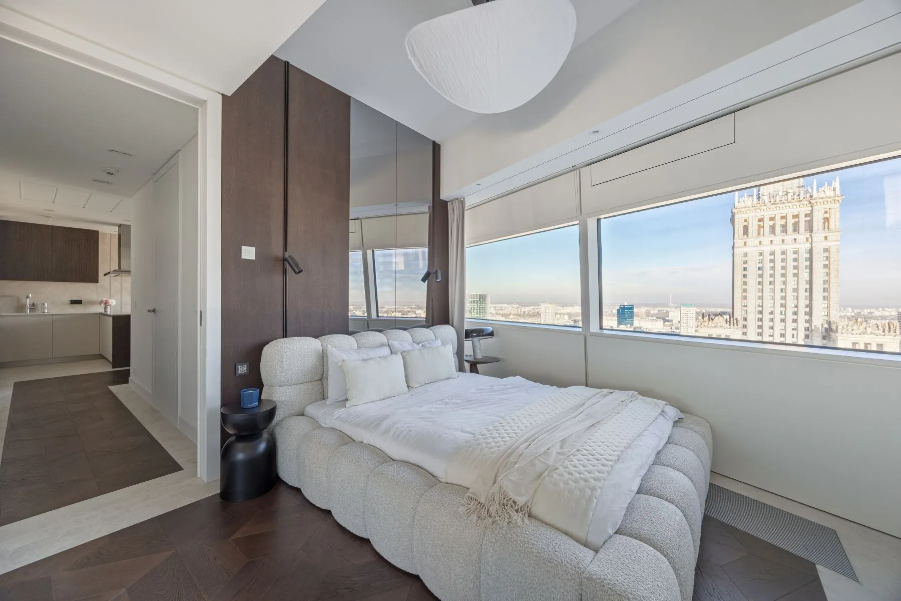 Principal double bedroom with upholstered bed and panoramic central Warsaw outlook