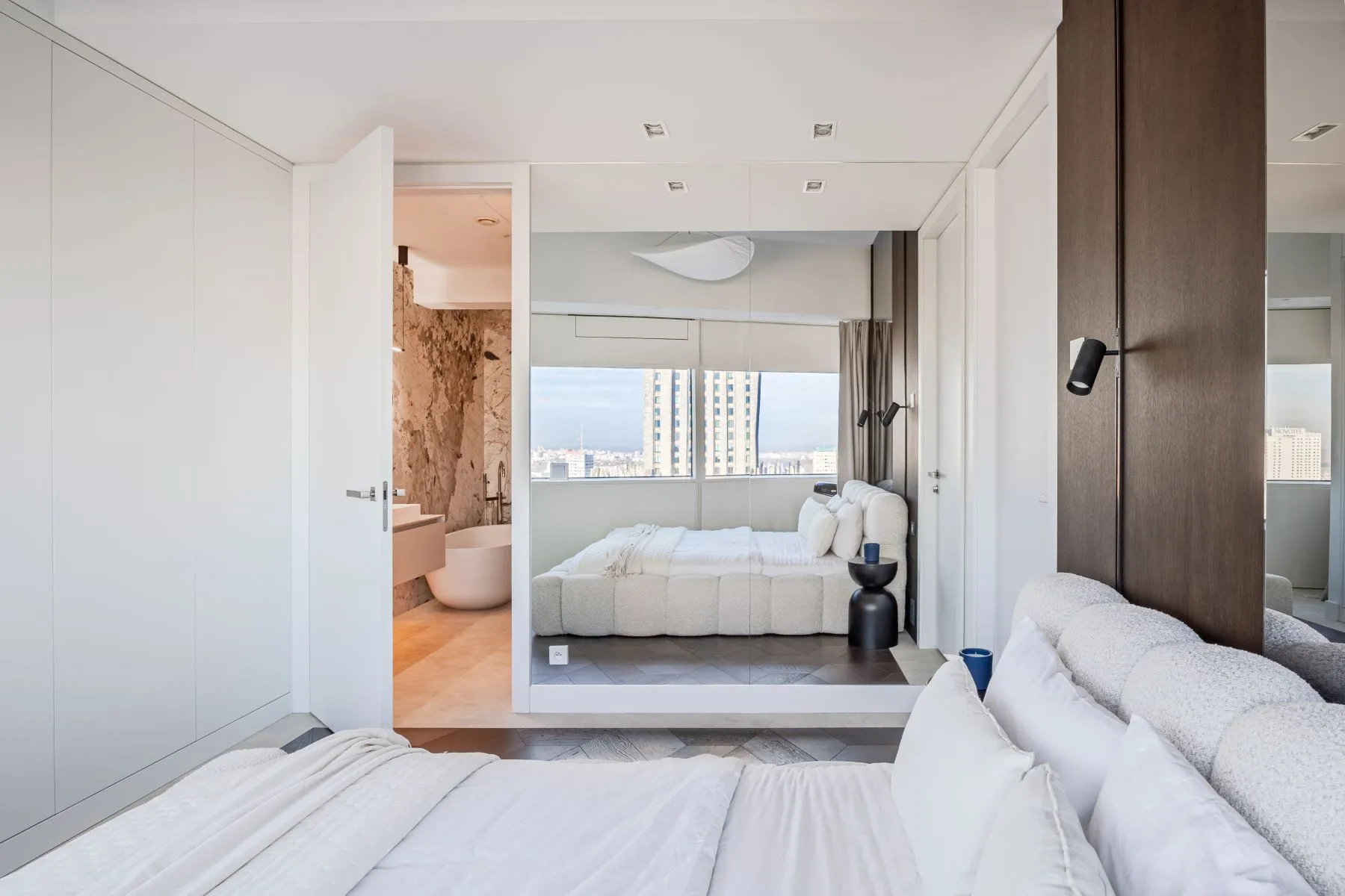 Principal bedroom with mirrored wardrobe doors and adjoining marble-finished bathroom
