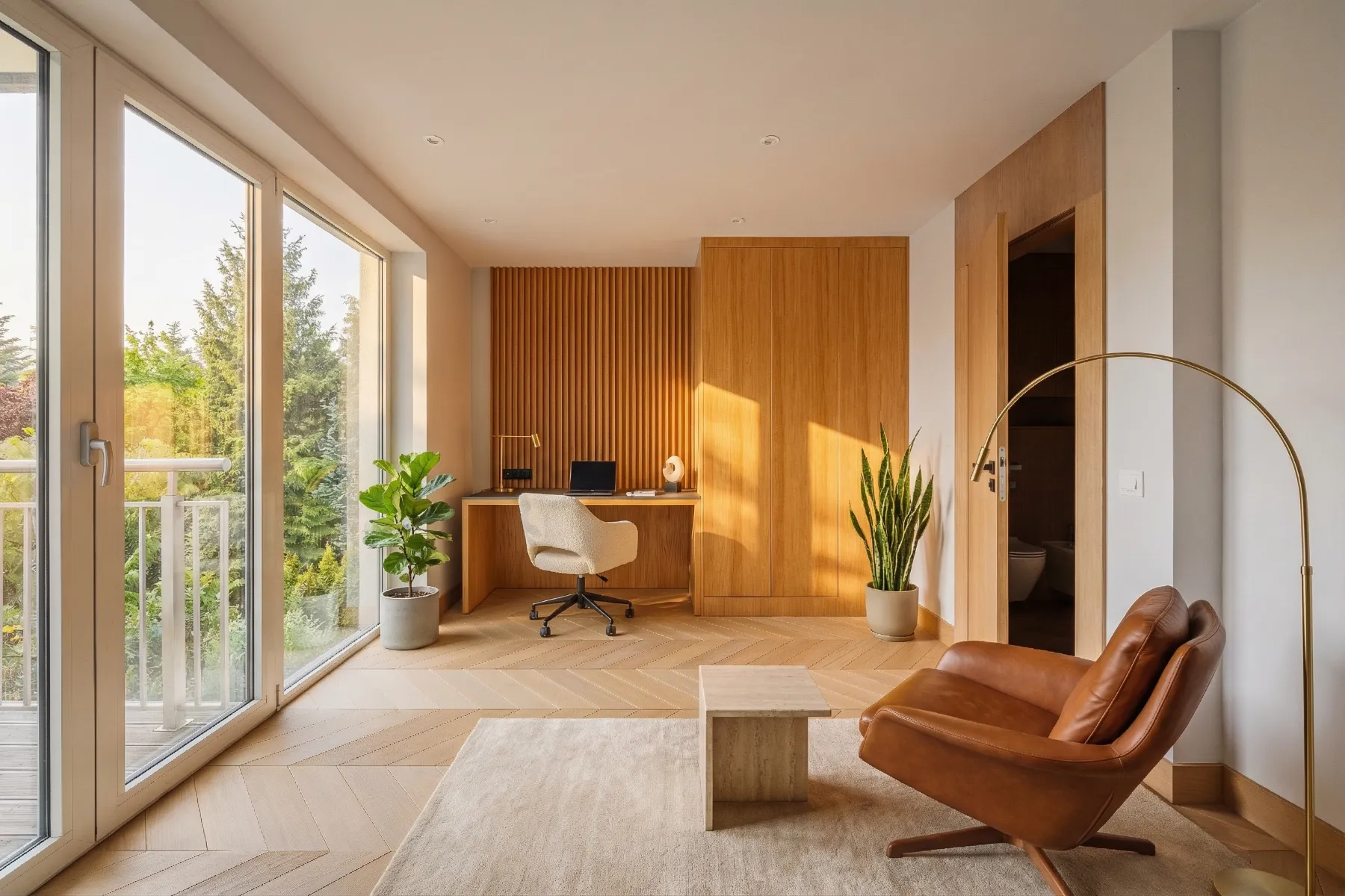 Dedicated workspace beside glazed outdoor-access doors and a leather lounge chair