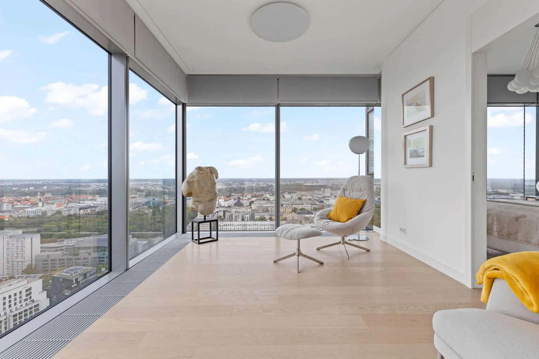 Bright window-side sitting area with pale timber flooring and floor-to-ceiling corner glazing