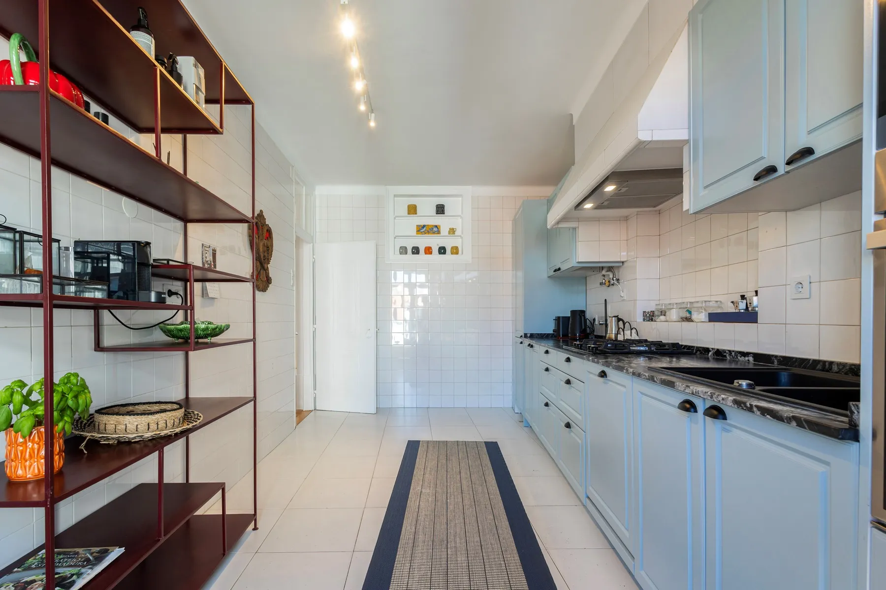 Galley kitchen with extensive storage open shelving and patterned runner