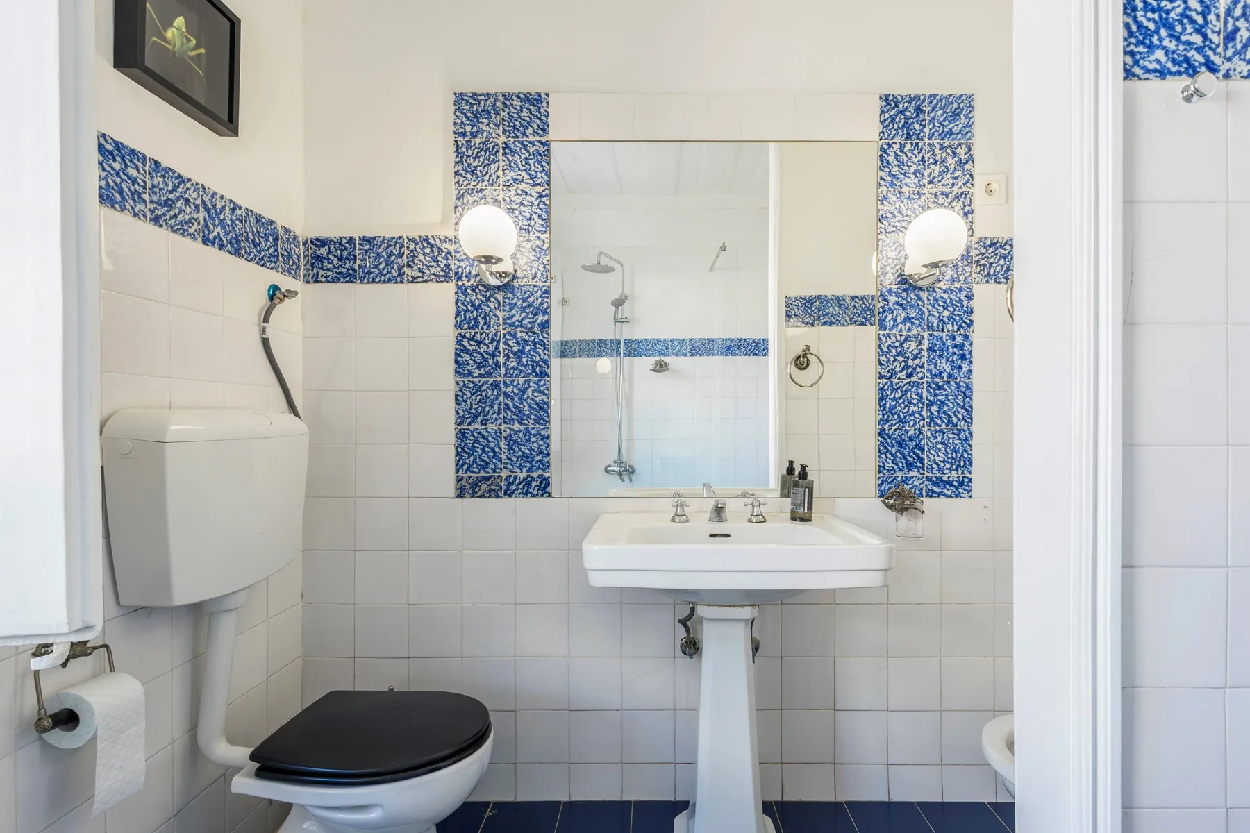 Blue mosaic bathroom with pedestal basin and wall mirror
