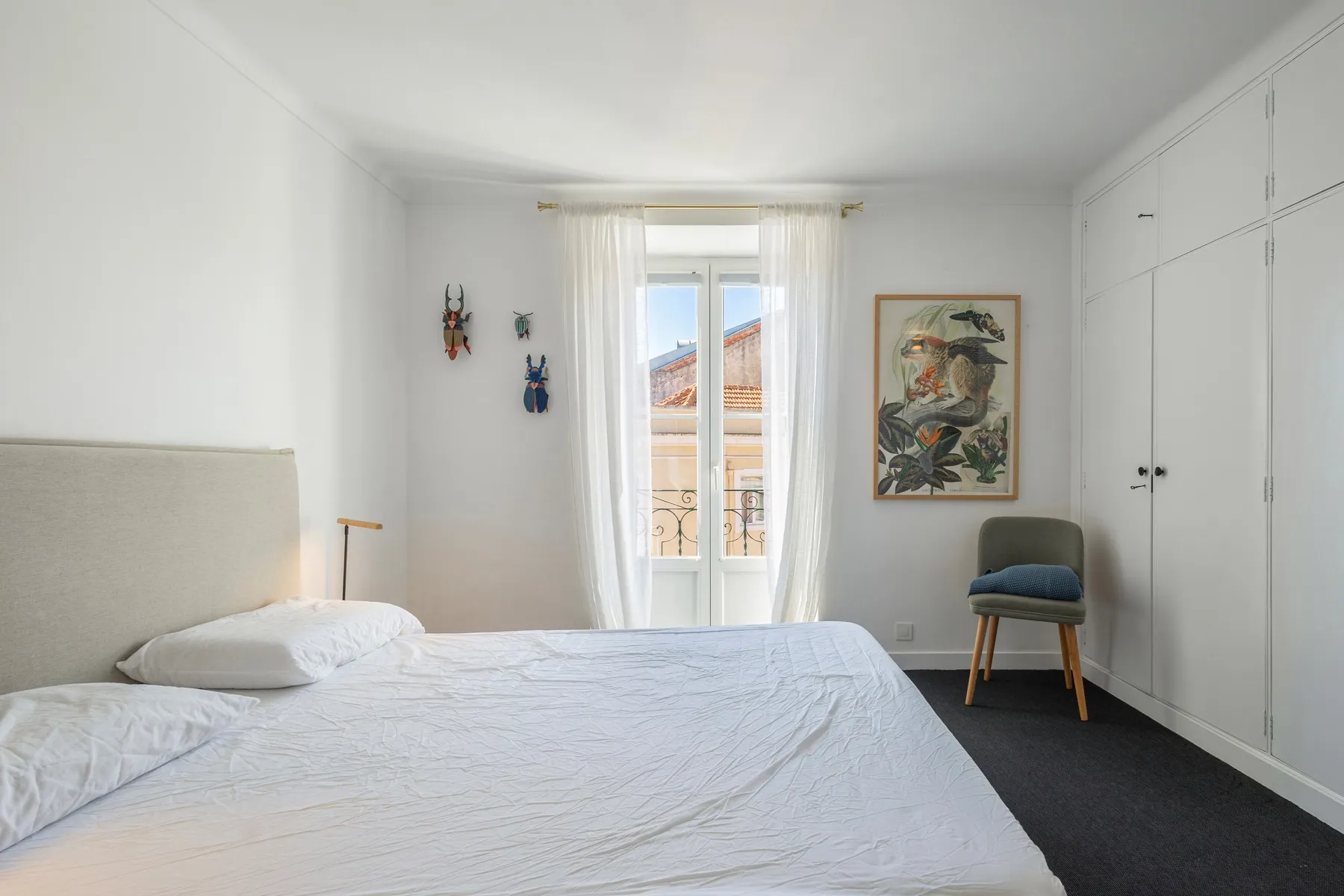 Bright double bedroom with artwork and extensive built-in storage