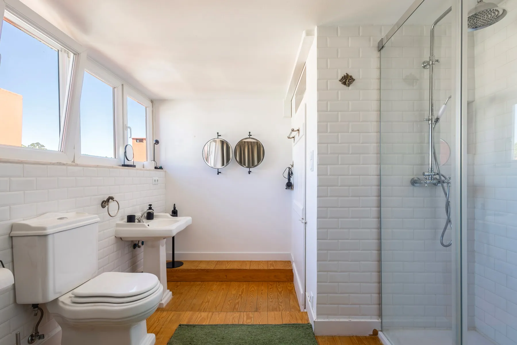 Family bathroom with glass shower enclosure beneath high windows