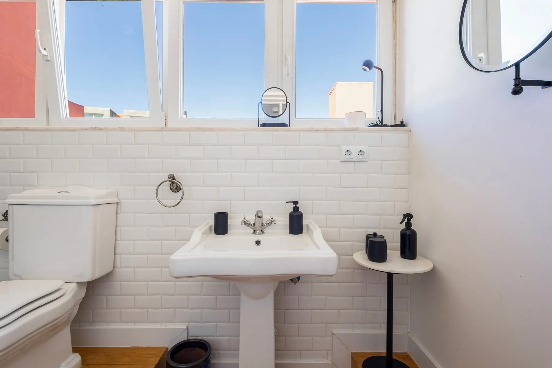 Compact third bathroom with pedestal basin and Lisbon rooftop glimpse