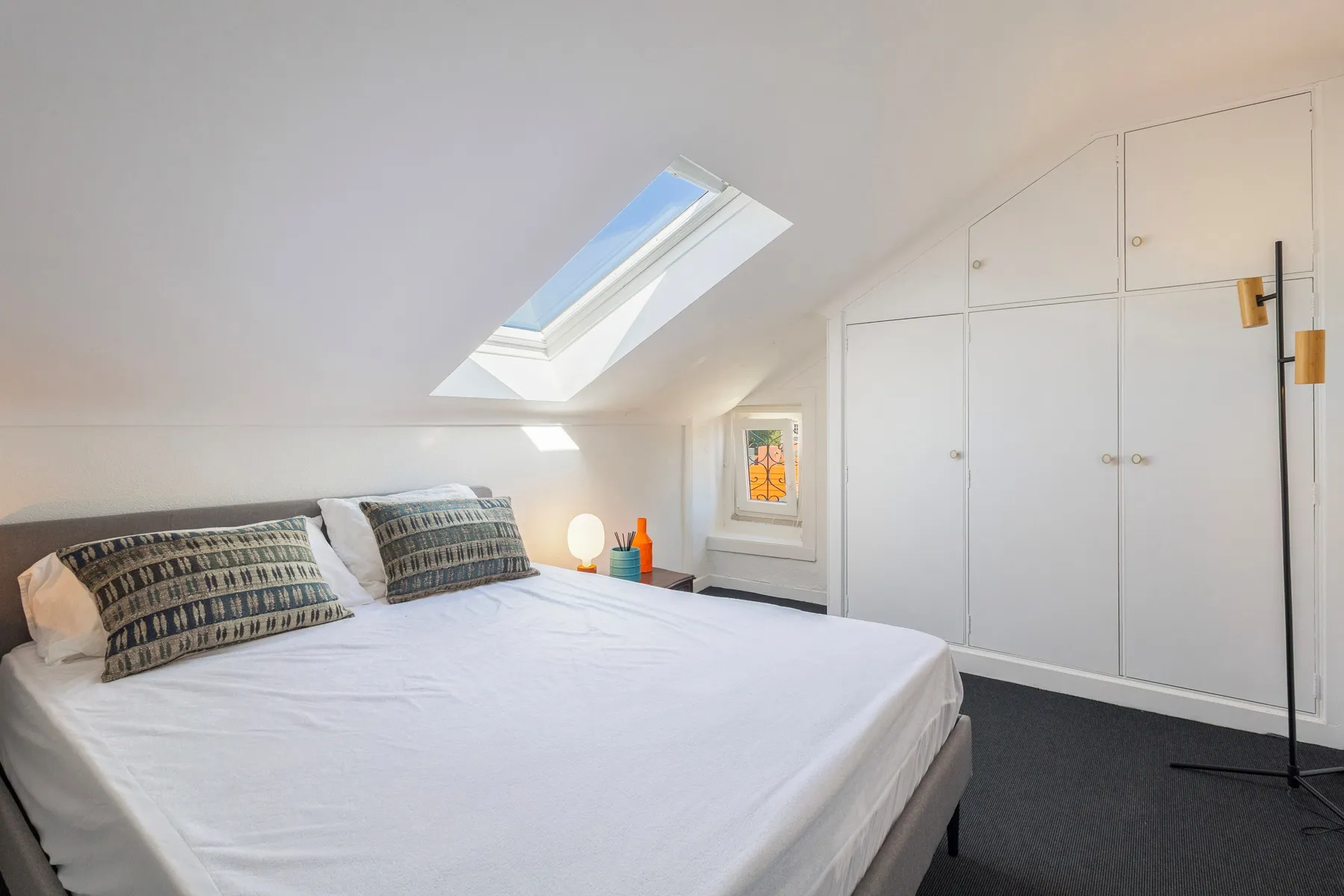 Upper double bedroom beneath the sloped roof with fitted wardrobes