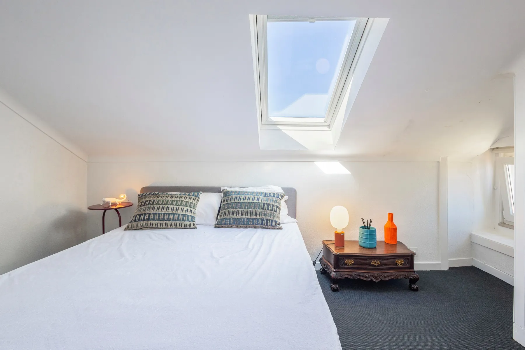 Restful attic bedroom illuminated by a large roof window