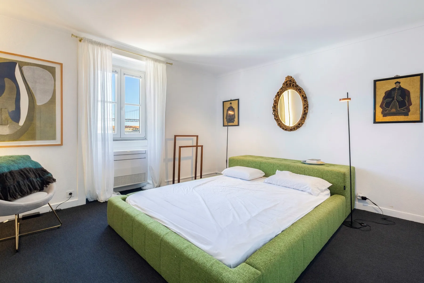 Flexible studio bedroom with green double bed and tall windows