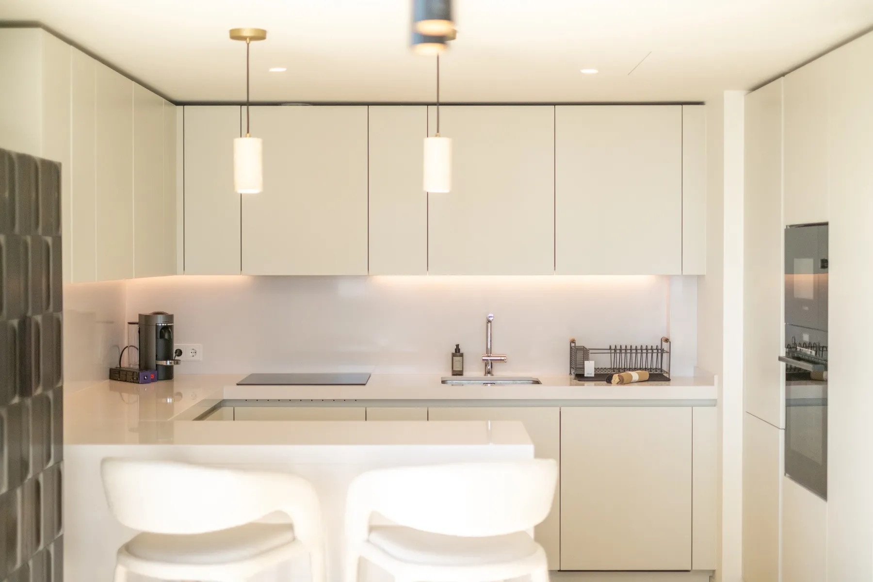 Streamlined kitchen cabinetry with illuminated splashback