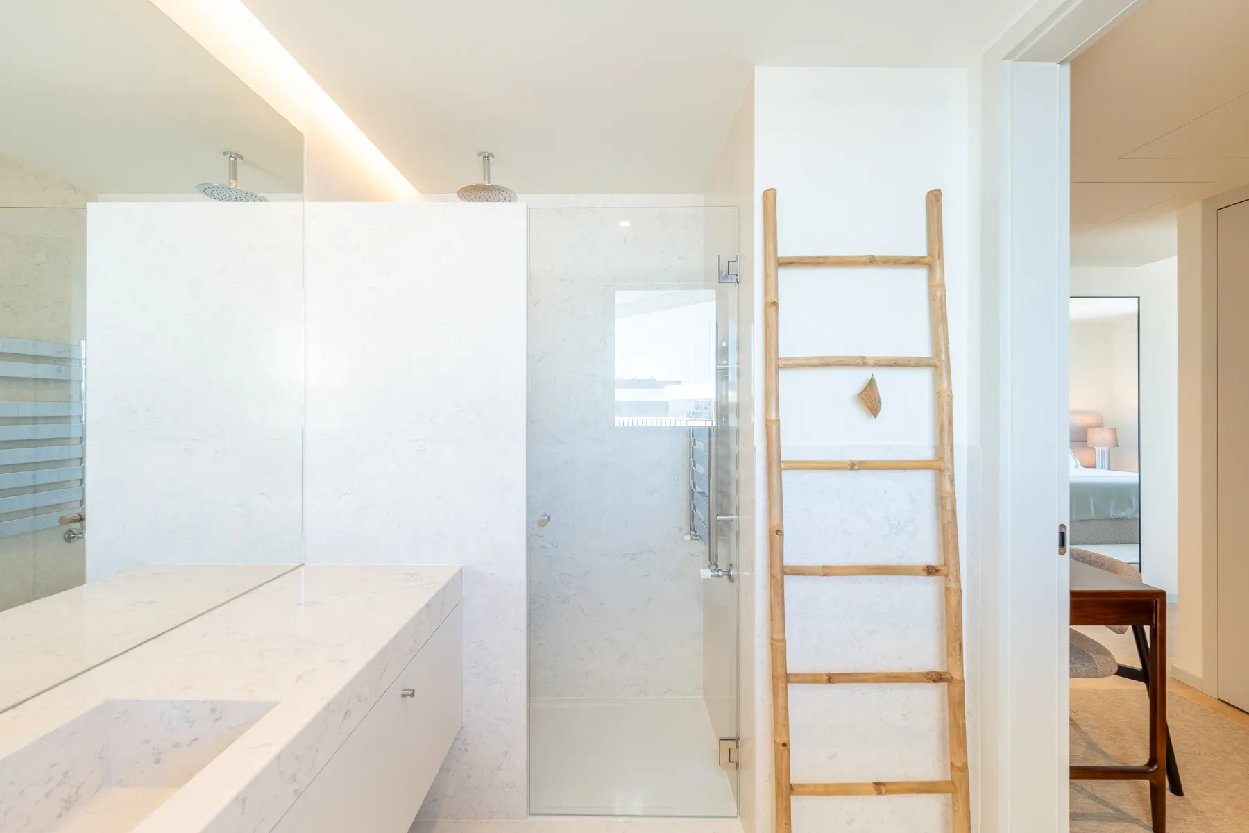 En-suite shower room with frosted glass partition and pale stone vanity