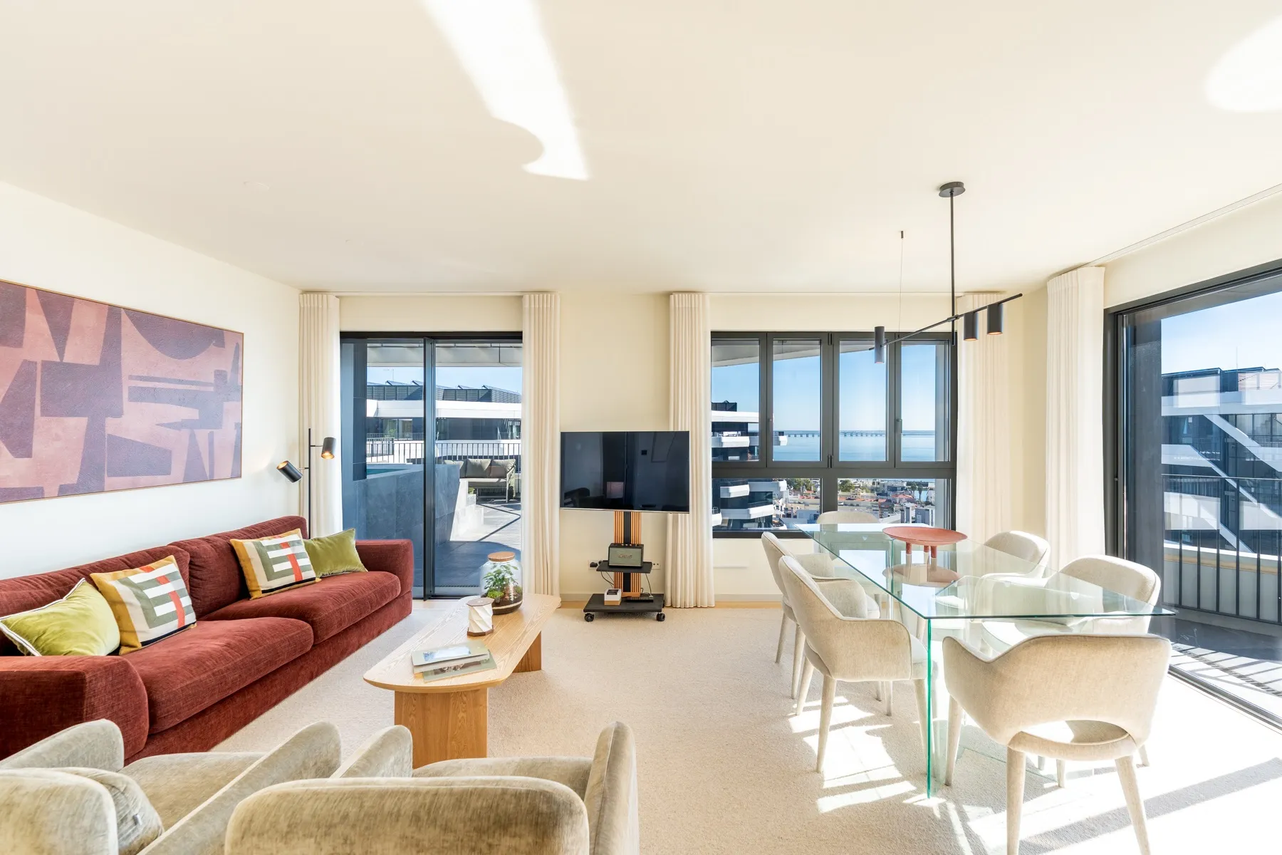 Sunlit open-plan living and dining area with panoramic glazing