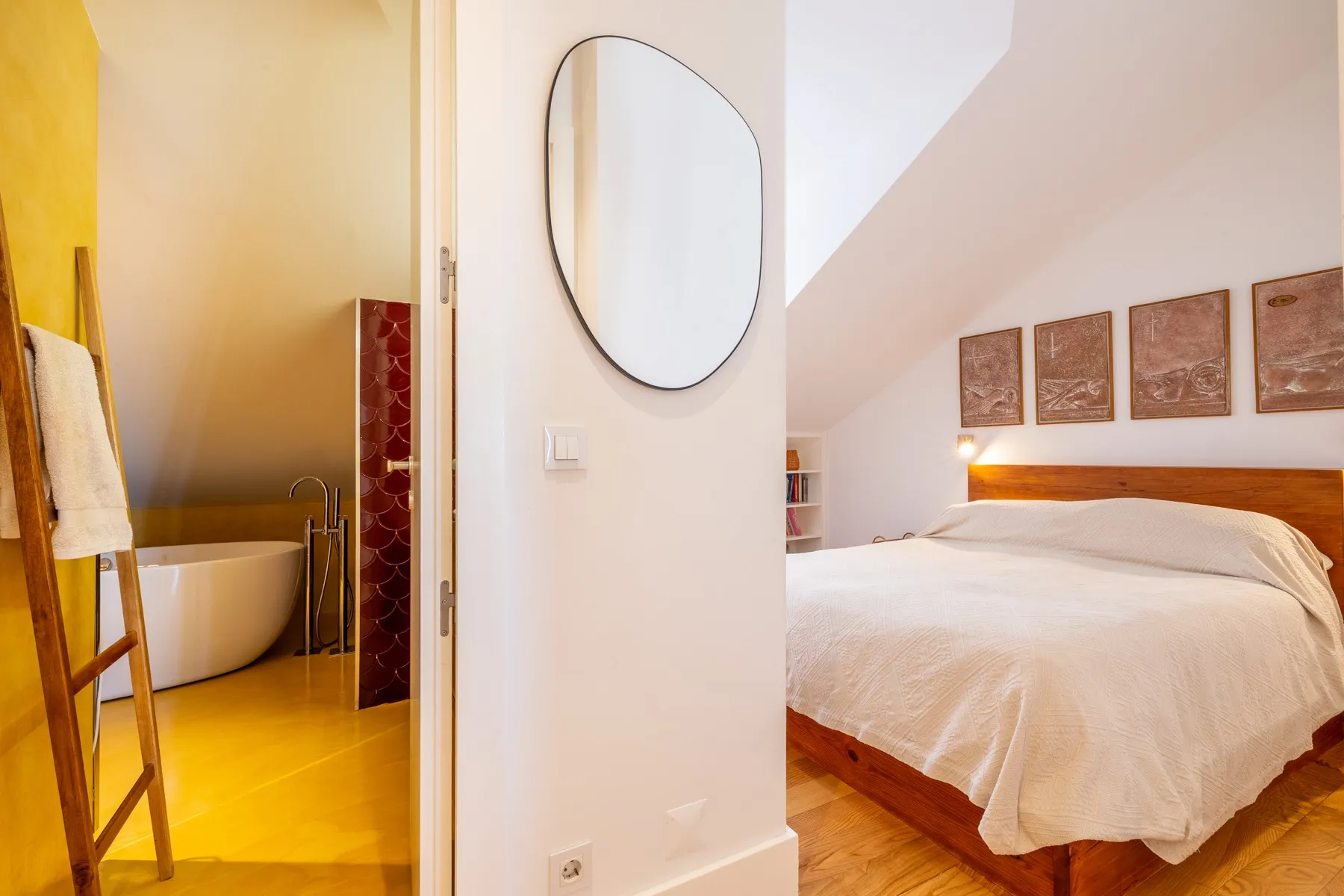 Principal bedroom entrance with circular mirror and private bathroom access