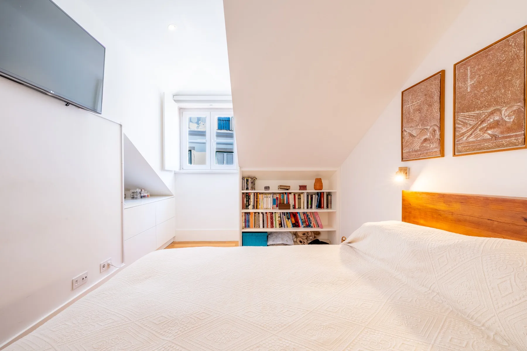 Principal double bedroom with low bookshelf beneath the window