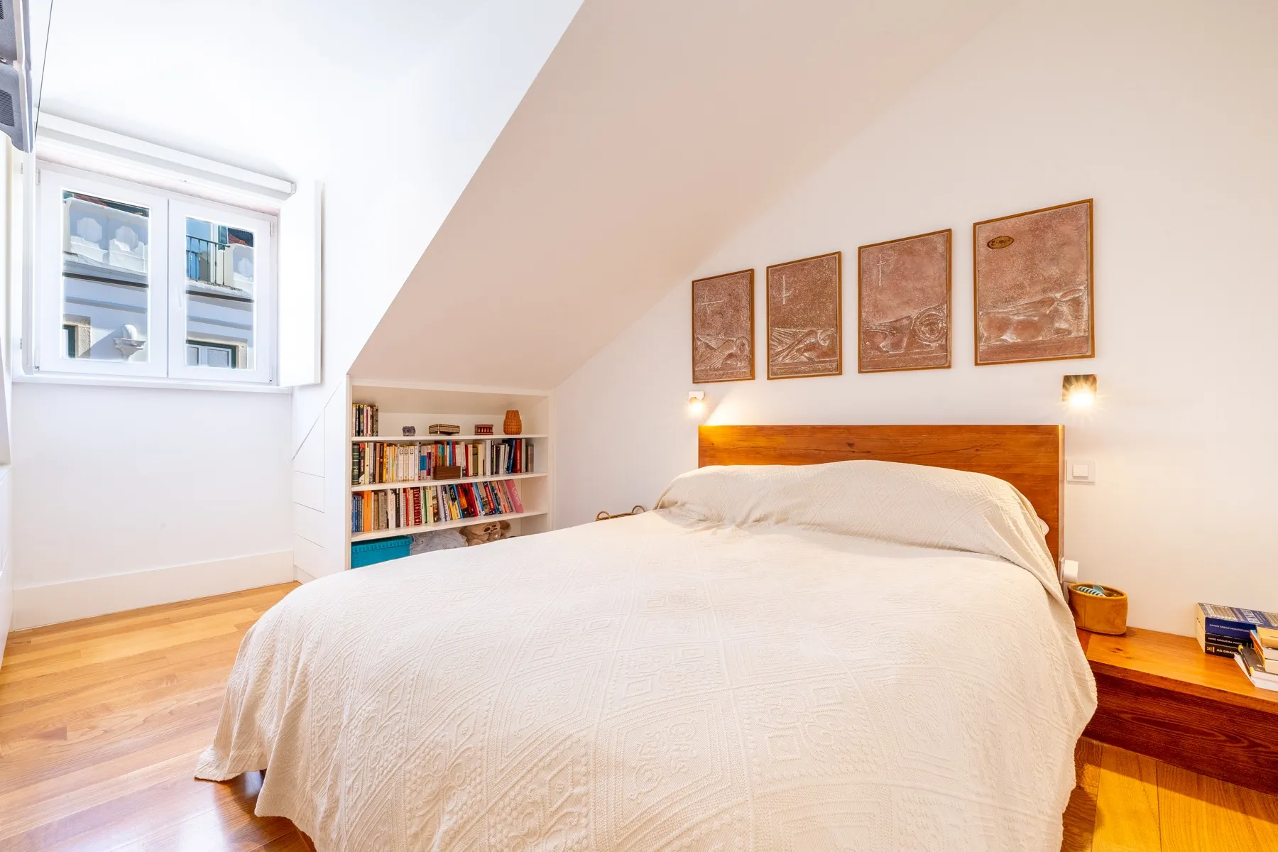 Bright double bedroom with warm timber floor and rooftop window