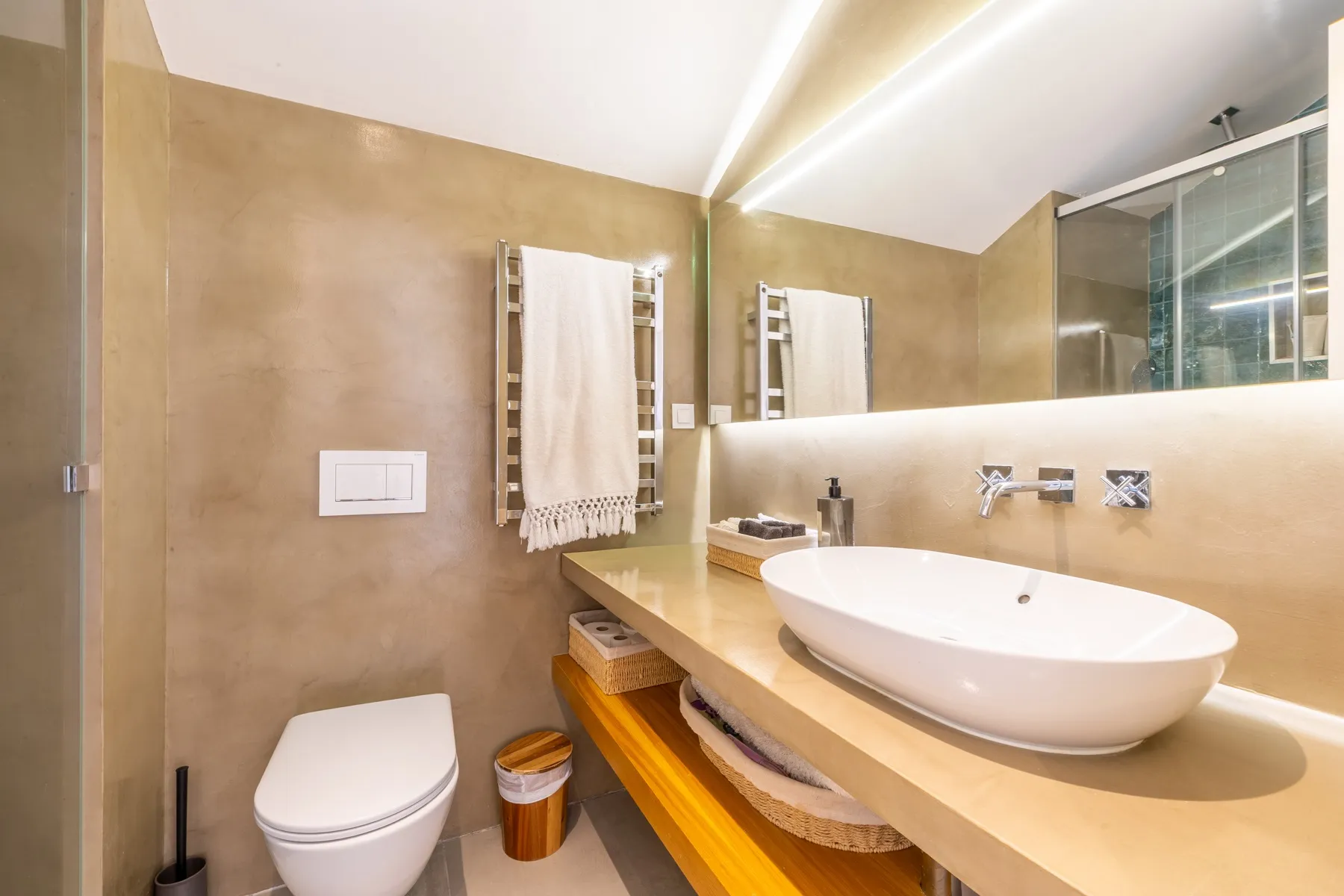 Second bathroom with glass shower wall basin and neutral stone finishes