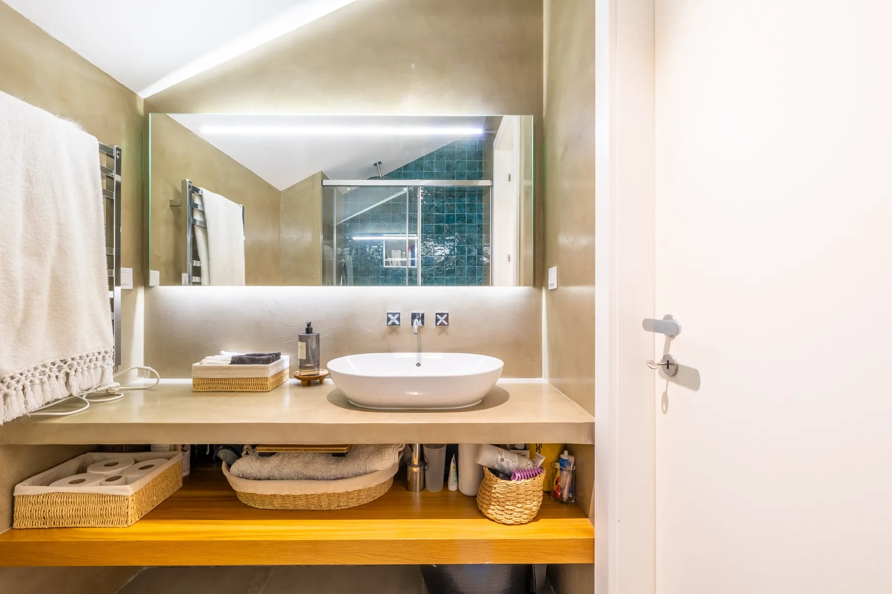 Wide mirrored vanity with open timber storage in the second bathroom
