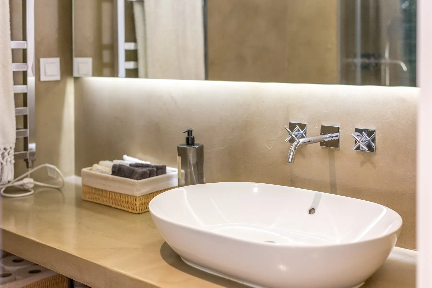 Stone-finished bathroom basin beneath soft integrated lighting