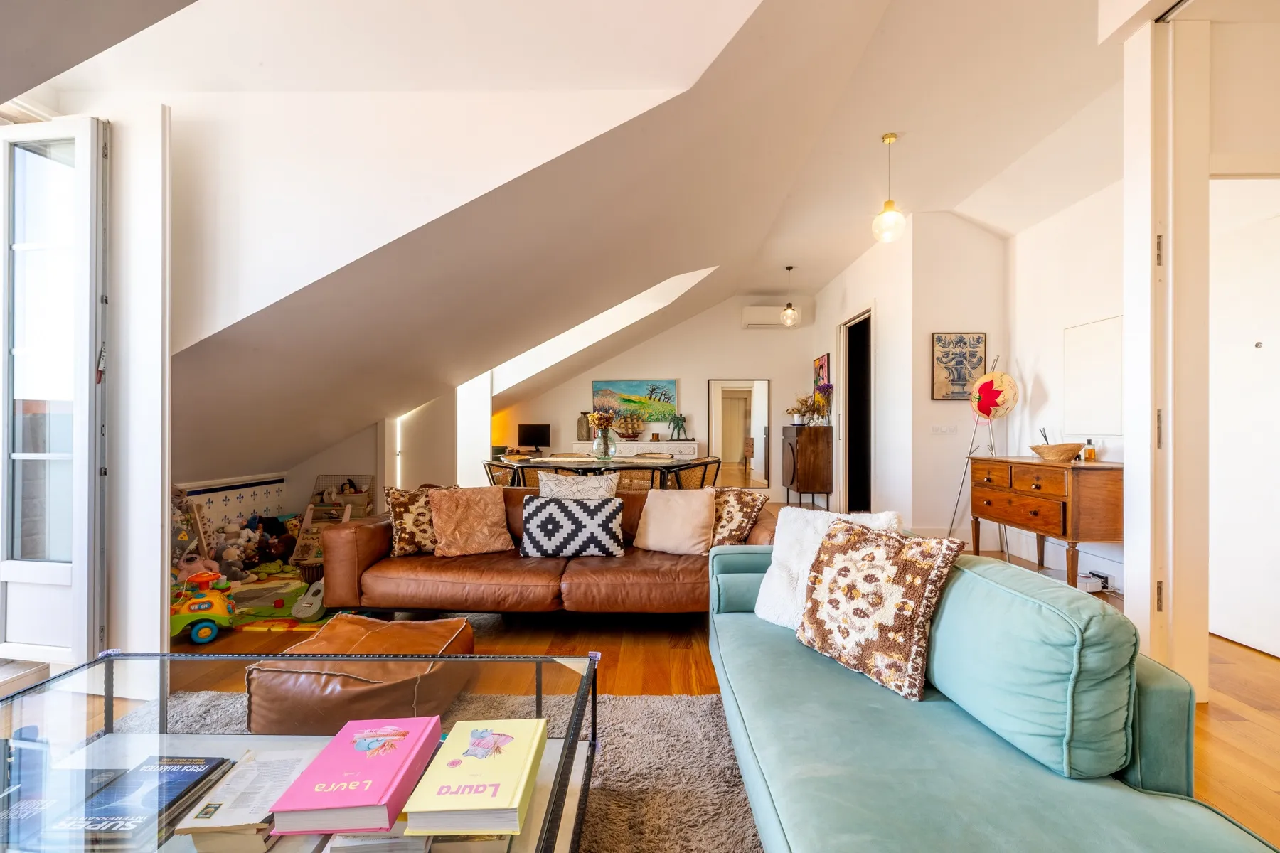 Spacious lounge with colourful seating timber floors and rooftop light