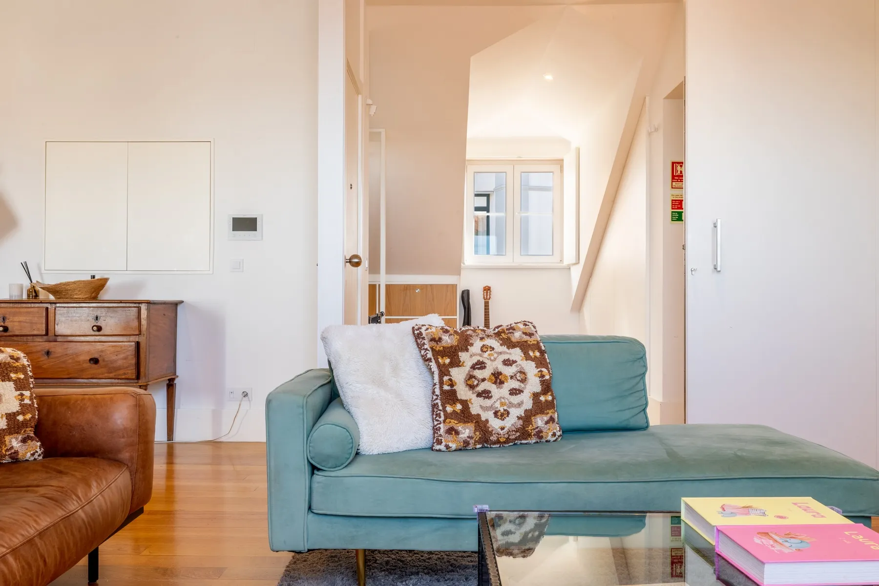 Bright lounge with teal chaise and direct access toward the view
