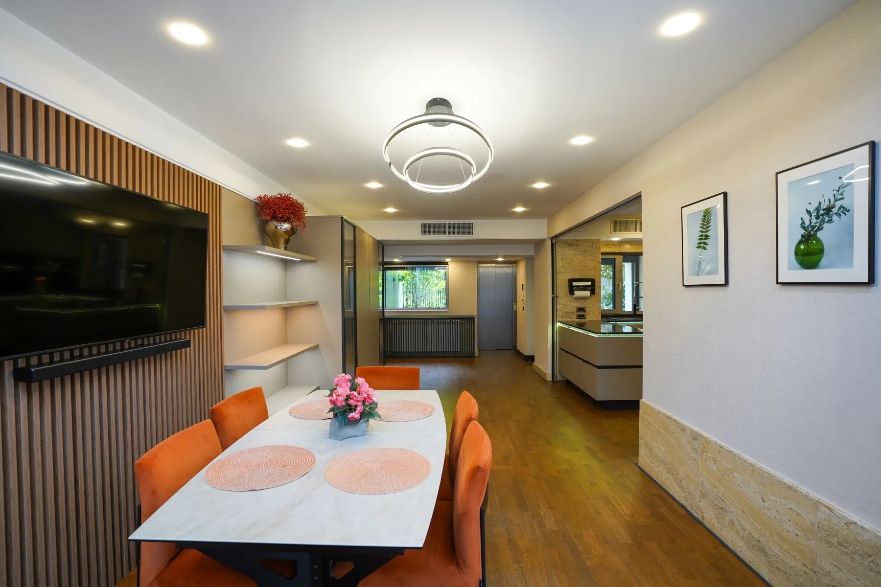 Bright dining area with television, sculptural lighting and garden outlook